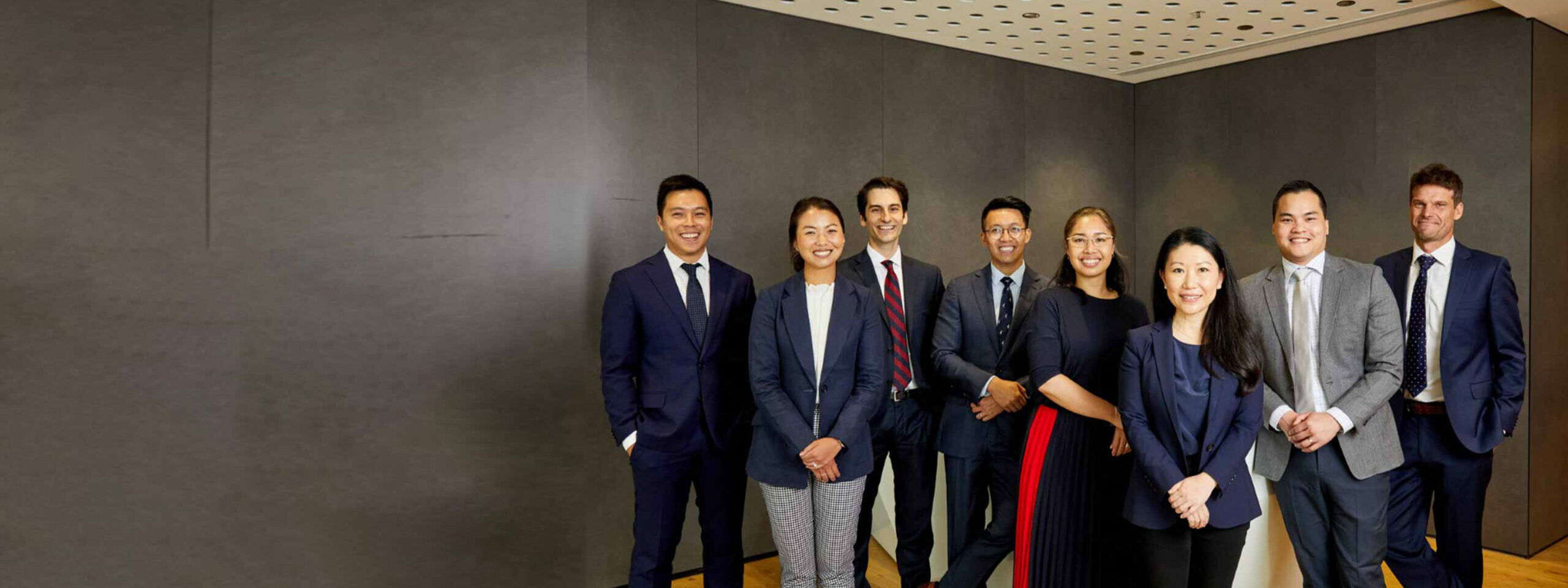 A group of 8 male and female new radiologists standing in the reception area of Jones Radiology