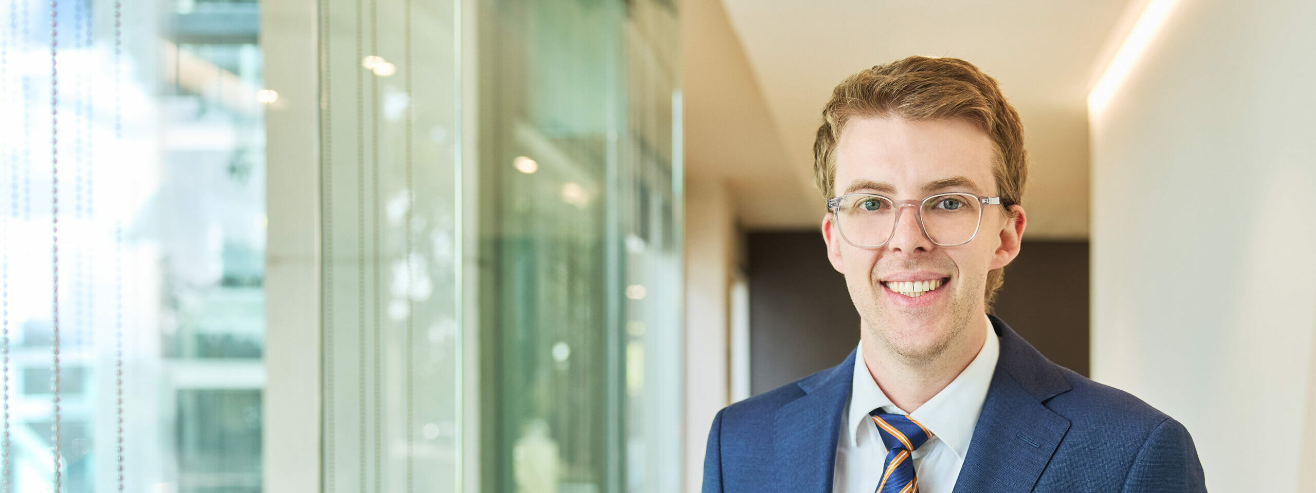 Dr George Hinton standing in a modern light filled building