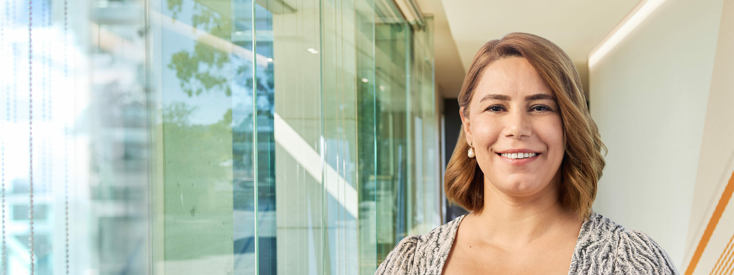Dr Suzan Bahadir pictured in a light filled, modern hallway